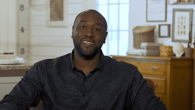 Friendly image of Speaker and Coach Darryll Stinson seated and smiling directly at the camera, likely a still from a welcome video or webinar.